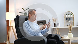 Happiness of wellness elderly asian man with white hairs sitting on sofa using mobile phone