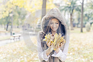 Happiness woman with authumn leaves on hands in the park.