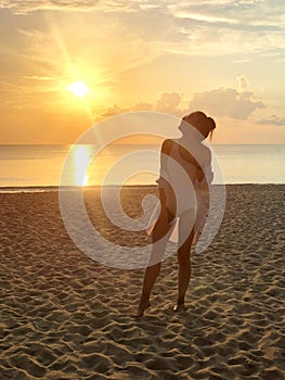 Happiness woman on beach. She is enjoying serene ocean nature sunset during travel holidays vacation outdoors. at phuket Thailand