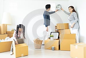 Happiness young Asian family unpacking cardboard boxes and moving into a new home.Moving house day and express delivery concept