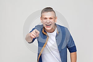 Happiness young boy pointing finger at camera and toothy smile.