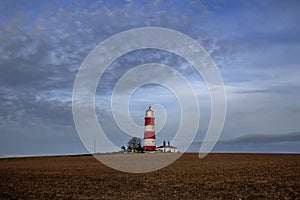 Happisburgh Lighthouse on the top of a hill on the coast of Norfolk