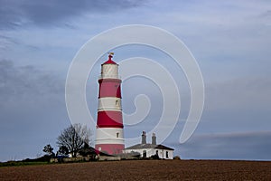 Happisburgh Lighthouse on the top of a hill on the coast of Norfolk