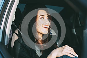 Happpy beautiful charming brunette long hair young asian woman in black leather jacket enjoing life in car window