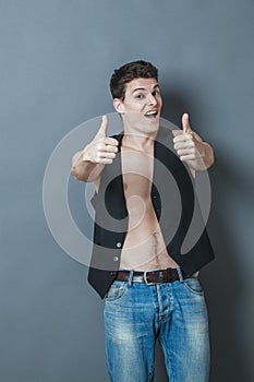 Happy 20s sportsman with bare chest and thumbs up