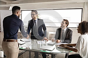 Happy 30s caucasian businessman shaking hands with arabian partner.