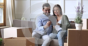 Happy 30s couple using tablet computer on moving day