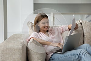 Happy 30s millennial homeowner woman making online payment on laptop