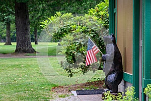 Happy 4th of July, wooden bear holding a US Flag, patriotic background