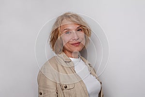Happy 60 years old businesswoman smiling on white background. Studio portrait of perfect mature lady
