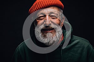 Happy 70-year-old optimist man with smiling wrinkled face, isolated on black