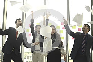 Happy achievement successful business people celebrating by throwing business papers and documents fly in the air  success