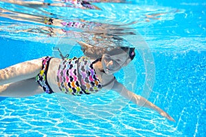 Happy active child swims freestyle in pool, underwater view photo