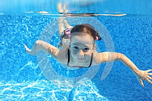 Happy active child swims underwater in pool