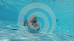 Happy active child swims underwater in the pool. Children's swimming, girl 5 years old in the swimming pool