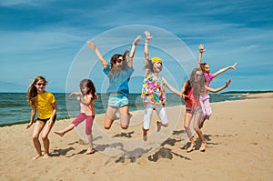 Happy active children jumping on the beach