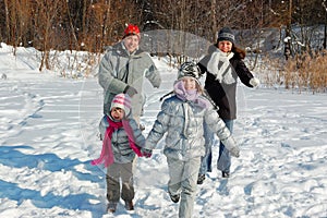 Happy family walks in winter, having fun and playing with snow outdoors on holiday weekend