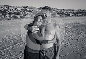 Happy active and healthy mature couple having fun on the beach enjoying outdoors lifestyle