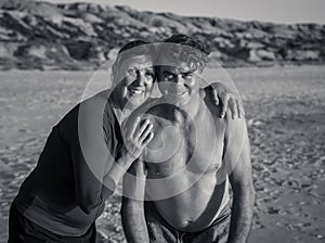 Happy active and healthy mature couple having fun on the beach enjoying outdoors lifestyle