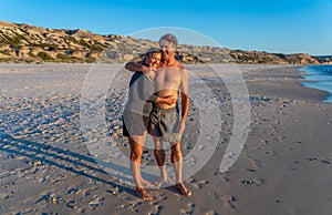 Happy active and healthy mature couple having fun on the beach enjoying outdoors lifestyle