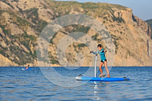 Happy active kid on a Hobie Stand Up Paddle board photo