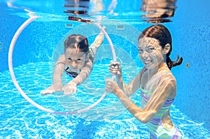 Happy active kids swim in pool and play underwater