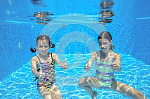 Happy active kids swim in pool and play underwater