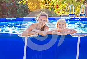 Happy active mother and child in swimming pool relaxing