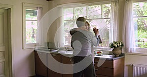 Happy active senior couple dancing in home kitchen