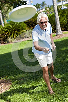 Happy Active Senior Man Throwing Frisbee Outside