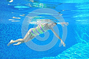 Happy active underwater child swims in pool