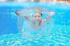 Happy active underwater child swims in pool