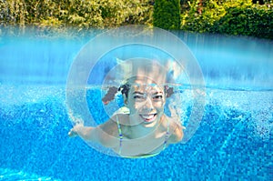 Happy active underwater child swims in pool