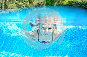 Happy active underwater child swims in pool