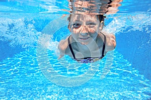 Happy active underwater child swims in pool