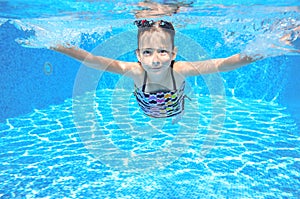 Happy active underwater child swims in pool