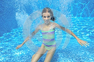 Happy active underwater child swims in pool