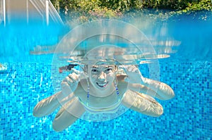 Happy active underwater child swims in pool