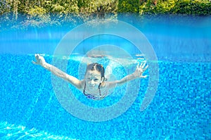 Happy active underwater child swims in pool