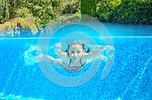 Happy active underwater child swims in pool