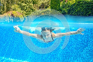 Happy active underwater child swims in pool