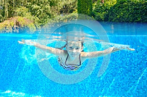 Happy active underwater child swims in pool