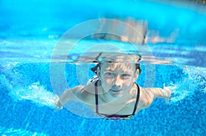 Happy active underwater child swims in pool