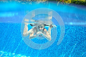 Happy active underwater child swims in pool