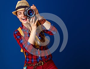 Happy active woman hiker with modern DSLR camera taking photo