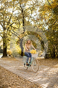 Happy active woman riding bicycle in autumn park