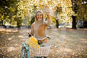 Happy active woman riding bicycle in autumn park