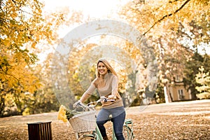 Happy active woman riding bicycle in autumn park