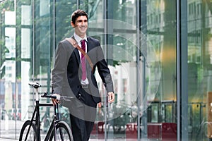 Happy active young man walking to the job after bicycle commutin