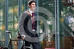 Happy active young man walking to the job after bicycle commutin